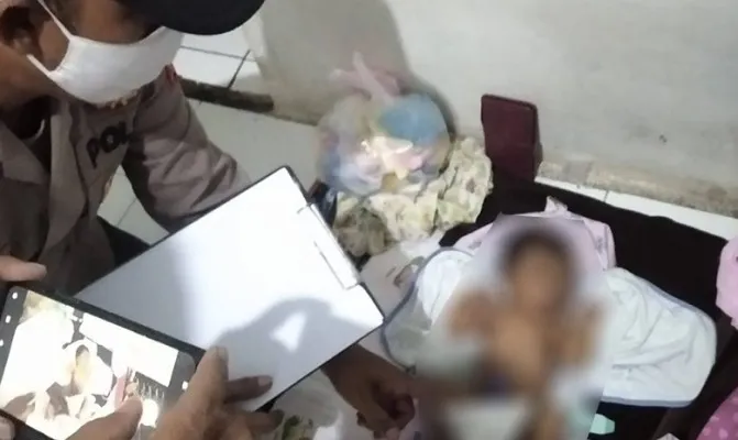 Anggota Bhabinkamtibmas Kelurahan Cinangka Aiptu Sudibyo mengecek kondisi bayi perempuan, dibuang orang tua, jadi rebutan warga Bojongsari Depok. (Foto/polseksawangan) 