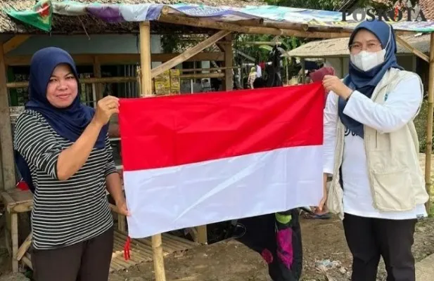 Kepala Puskesmas Patia, Pandeglang saat membagikan bendera merah putih kepada warga. (Foto: Samsul Fatoni)