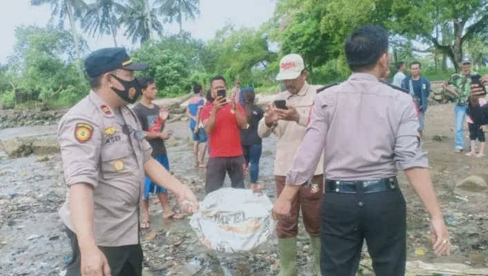 Polisi saat evakuasi jasad bayi di pantai Kecamatan Panimbang, Pandeglang. (Foto:Ist).