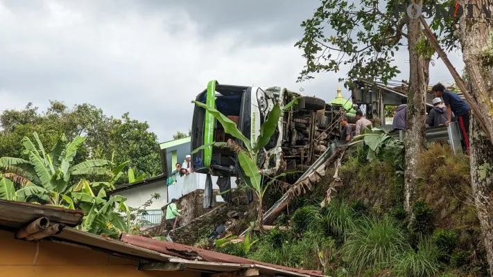 Proses evakuasi bus pariwisata yang terperosok hingga menimpa rumah warga di kawasan Puncak Bogor pada Sabtu, 3 Agustus 2024. (Poskota.co.id/Panca Aji)