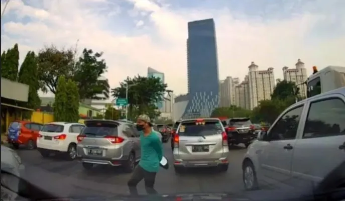 Seorang pria nekat mencuri spion mobil ditengah kemacetan. (Tangkapan Layar)