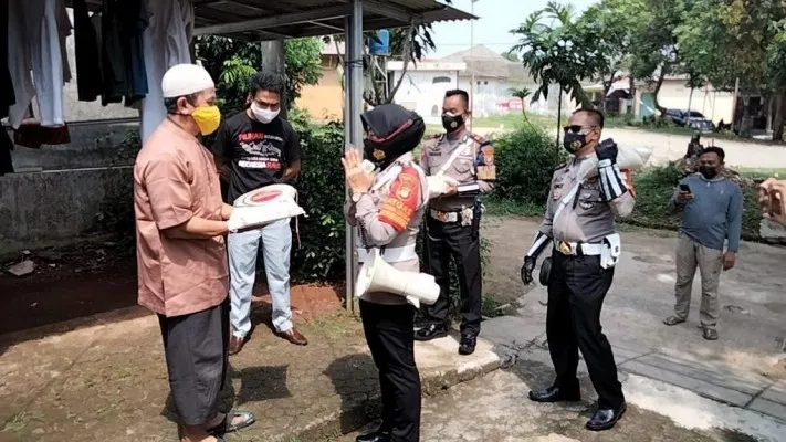 Kanit Kamsel Satlantas Polres Metro Depok AKP Elly dengan Kanit Turjawali AKP Firdaus jemput bola bersama anggota membagikan puluhan paket sembako ke rumah warga. (Foto/angga) 