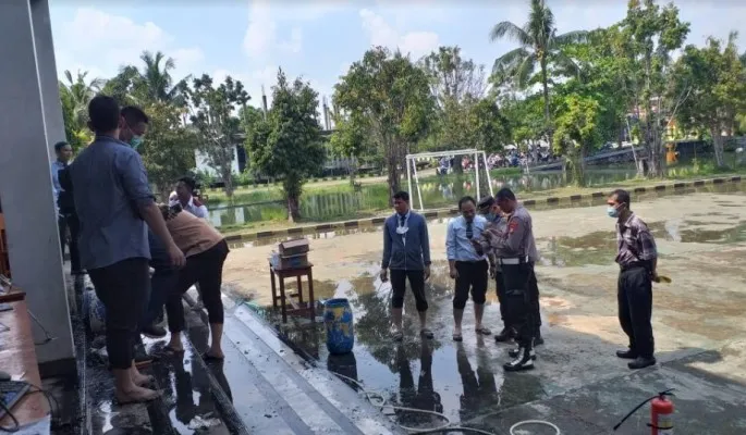 Para guru dibantu siswa sedang membersihkan ruangan lab komputer usai terbakar. Wakapolsek Cinere AKP Jajang Rahmat lakukan olah TKP