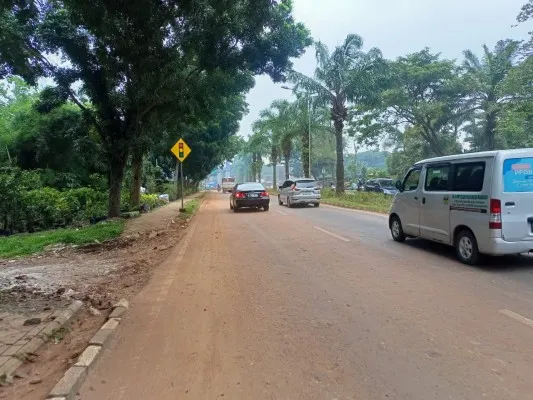 Jalan Raya Pemda, Kabupaten Tangerang tertutup ceceran tanah merah dari aktivitas galian ilegal.(Poskota.co.id/Veronica Prasetio)