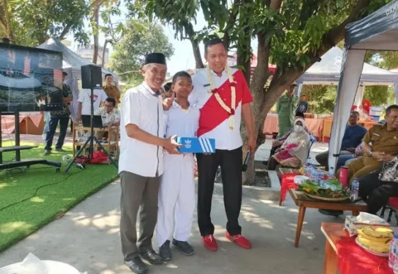 Wali Kota Bekasi, Tri Adhianto foto bersama anak SD yang mendapat hadiah sepatu, didampingi Kepala SDIT Al Insanul Kamil, Hanafi. (Ist)