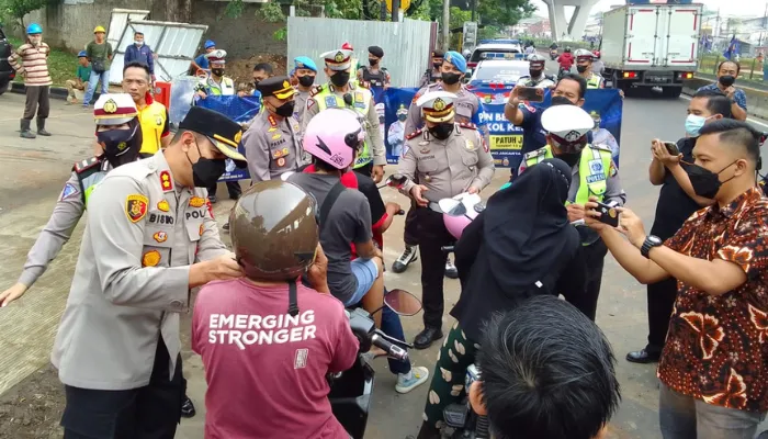 Polisi bagikan 100 helm SNI gratis untuk pelanggar Operasi Patuh Jaya 2022 di Pesing, Jakarta Barat. (Poskota/Pandi Ramedhan)