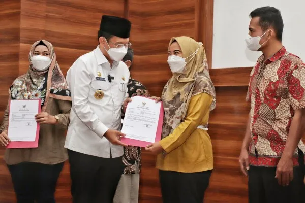 Pj Bupati Bekasi, Dani Ramdan meyerahkan NIB kepada pedagang melalui prgram Kemenkop dan UKM. (Ist)