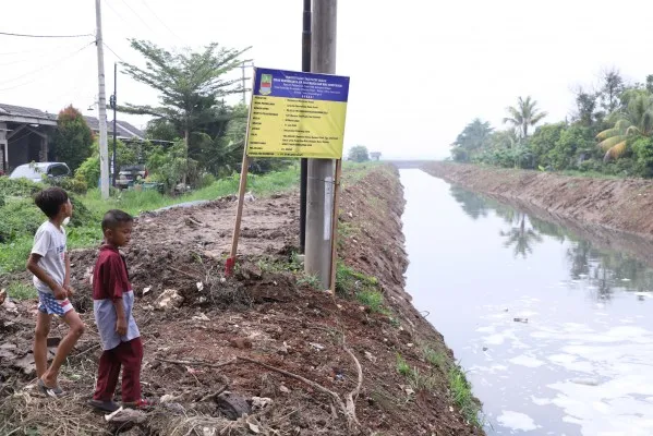 Dua anak sedang melihat kondisi salah satu kali yang akan dinormalisasi di kawasan Cikarang Utara, Kabupaten Bekasi. (Dok. Diskominfo Kabupaten Bekasi)