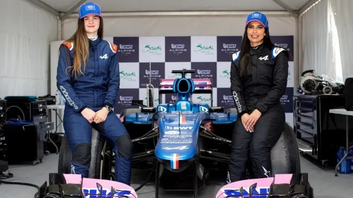 Abbi Pulling (kiri) dan Aseel Al Hmad (kanan) sedang berpose di mobil F1 nya(sumber foto: Formula 1)