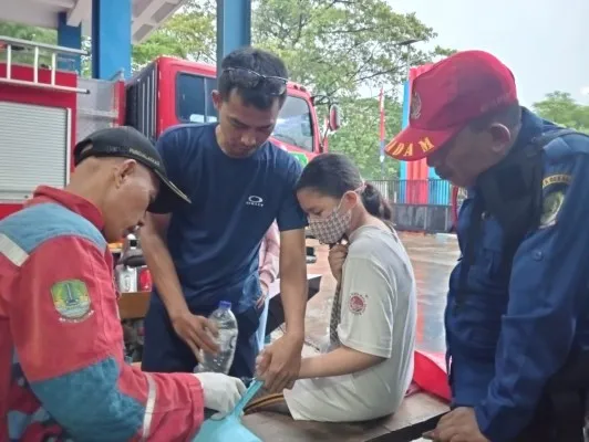 Petugas Damkar Kota Bekasi saat mengevakuasi jari bocah tersangkut lubang gayung. (Istimewa)