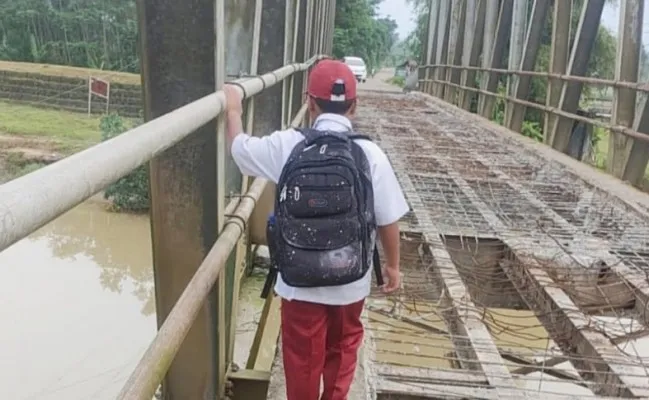 Salah seorang pelajar saat melintas di proyek jembatan Surianen, Pandeglang. (Foto: Ist).