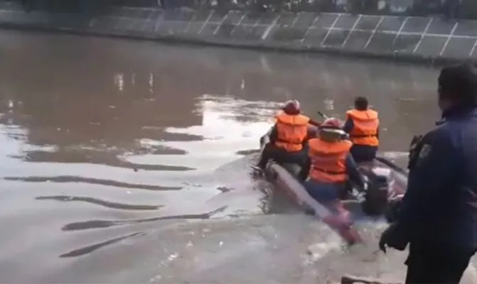 Petugas Sudin Gulkarmat Jakarta Timur melakukan pencarian pemuda yang terpeleset saat sedang berjalan di bantaran Kali Ciliwung.(Foto/gulkarmatjakartatimur)