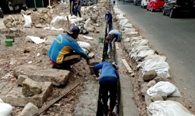 Petugas SDA Kelapa Gading saat mengeruk sampah dan lumpur di saluran air Jalan Kelapa Puan Raya, Kelapa Gading Timur. (Foto/sdakelapagading)