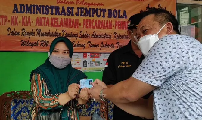 Ibu Eis saat prosesi serah terima KTP di lokasi saat petugas Suku Dinas Kependudukan Catatan Sipil Jakarta Timur melakukan pelayanan home service. (Foto/cr11)