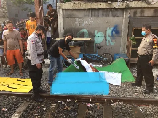 Petugas memeriksa jasad pria tertabrak kereta api di Pademangan, Jakarta Utara. (Ist)