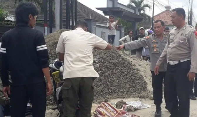 Petugas kepolisian saat mengevakuasi seorang penumpang sepeda motor yang tewas di Cikarang, Bekasi. (Humas Polres Metro Bekasi).