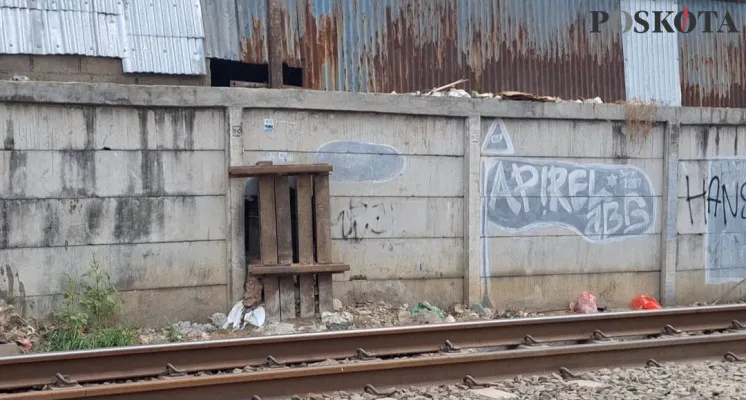 Kondisi lubang pada tembok pembatas jalur kereta api di Pasar Baru, Bekasi Timur, Kota Bekasi setelah ditutup oleh PT KAI. (Poskota/Ihsan Fahmi)