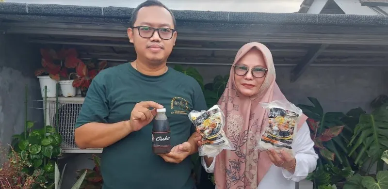 Ida Wahyuni akrab disapa Mama Syifa,  bersama suami menunjukan makanan pempek buatannya yang sudah di pack untuk dikirim ke luar kota. (Angga)