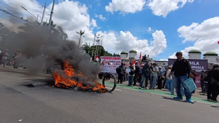 Massa aksi yang tergabung dalam Gerakan Masyarakat Tolak Pilpres Curang membakar ban di depan Gedung DPR RI, Jalan Jenderal Gatot Subroto, Jakarta Pusat (Jakpus).(Poskota.co.id/Rizal Siregar)