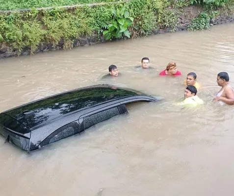 Warga mengevakuasi sopir taksi online (taksol) yang terperosok ke Sungai Cibarengkok, Kabupaten Bogor. (Dok: Warga)