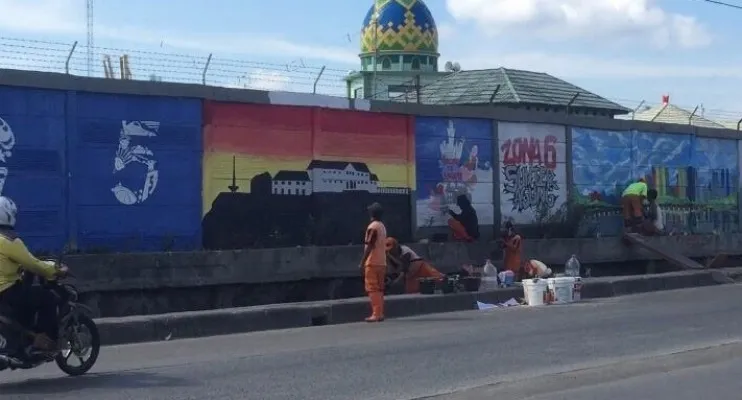 Petugas PPSU dan Karang Taruna Tanjung Priok menggambar mural di sepanjang Jalan R.E Martadinata, Ancol, Jakarta Utara.(CR06)