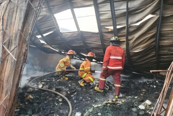 Petugas damkar kota Bekasi saat memadamkan api di gudang obat nyamuk. (Ist).