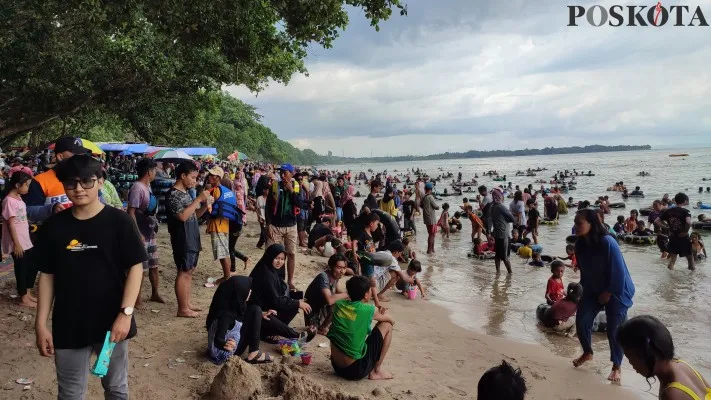 Wisatawan yang berlibur di Pantai Carita, Kabupaten Pandeglang. (Poskota.co.id/Samsul Fathony)