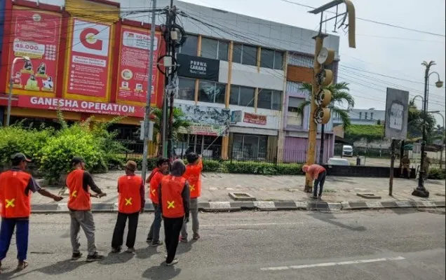 Petugas merobohkan kontruksi papan reklame yang tak berizin di sekitar Jalan Ahmad Yani Karawang.(Ist)