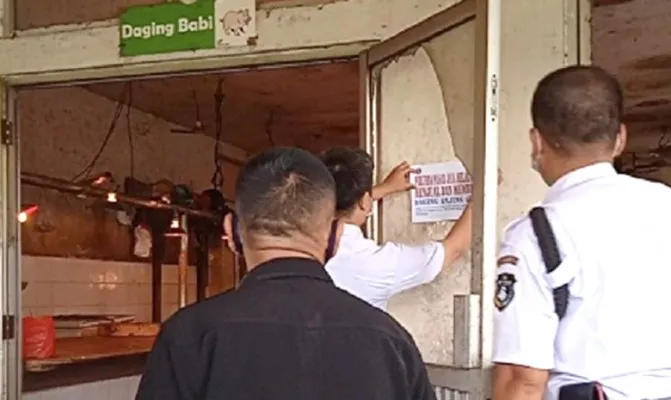 Cegah penjualan daging anjing petugas pasang stiker larangan menjual daging anjing di Pasar Koja Baru, Koja, Jakarta Utara. (Foto/yono))