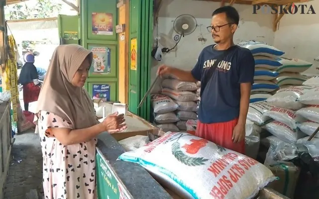 Salah seorang pedagang beras di Pasar Rangkasbitung Lebak saat melayani konsumen. (Foto Samsul Fatoni).