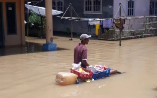 Salah seorang penjual buah-buahan di Idaman Pandeglang saat berkeliling di tengah banjir. (Dok. Kades Idaman)