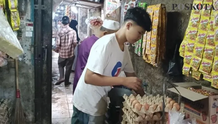 Salah seorang pedagang telur ayam di pasar badak Pandeglang sedang mengepak telur. (Foto: Samsul Fatoni).