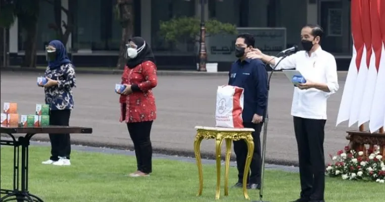 Presiden Jokowi saat menyerahkan bantuan obat gratis untuk warga yang isoman di halaman Istana.(setkab)