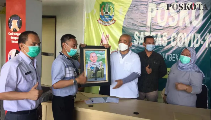 Pemred Poskota Tatang Suherman Didampingi Wapemred Tri Broto menyerahkan kenang-kenangan pada Wali Kota Bekasi Rahmat Effendi yang didampingi Kabag Humas Kota Bekasi Sajekti Rubiah dan Staf Humas Muchlis (paling kiri).(cr02)
