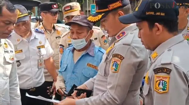 Petugas Dishub Jakbar berbicara dengan seorang jukir liar saat penertiban. (Poskota.co.id/Pandi Ramedhan)