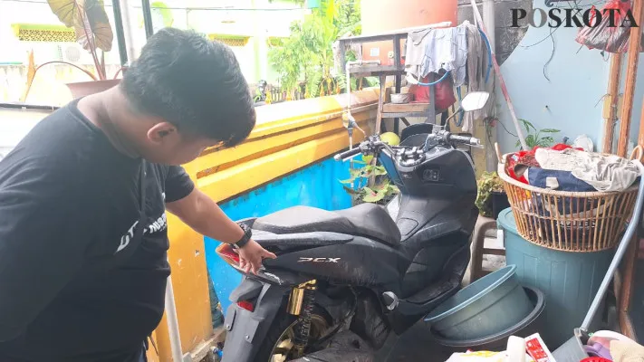 Warga saat memperlihatkan bercak siraman air keras yang sempat menempel di sepeda motor Honda PCX milik korban VU, di Medan Satria, Kota Bekasi, Rabu, 4 Desember 2024. (Poskota/Ihsan Fahmi)