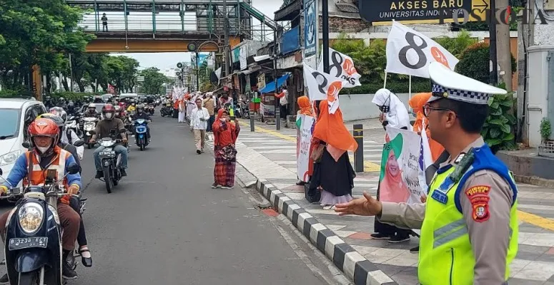 Brigadir Dani Satlantas Polres Metro Depok melakukan pengamanan para kader dan relawan yang sudah berjejer di Jalan Margonda. (Angga)