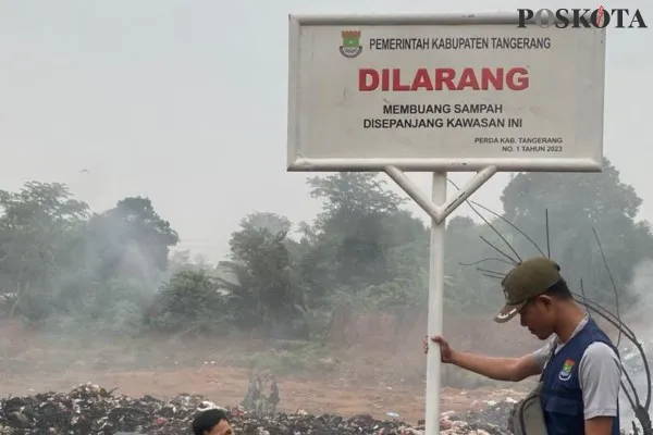 Petugas DLHK Kabupaten Tangerang saat kembali memasang plang yang dirobohkan di wilayah Kelurahan Kaduagung, Kecamatan Tigaraksa, Kabupaten Tangerang. (Poskota.co.id/Veronica Prasetio)