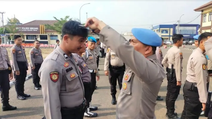 Kasie Propam Polres Serang Ipda Paruhuman Rangkuti saat memotong rambut rambut yang tidak sesuai prosedur. (ist)