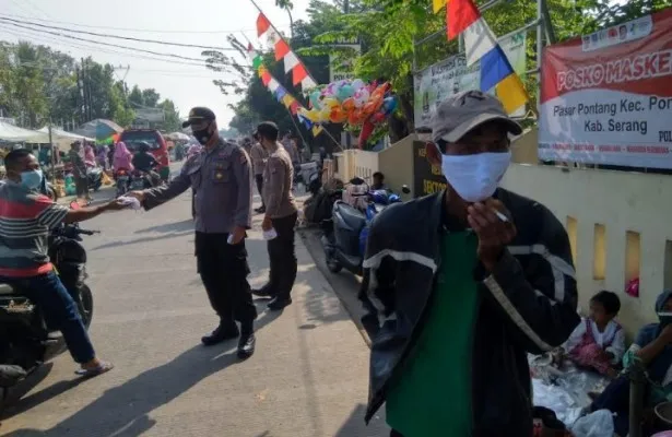 Personel polres Serang membagikan masker di pasar pontang. (ist)