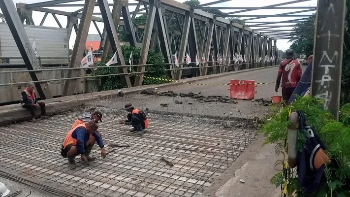 Petugas sedang melalukan perbaikan lubang di Jembatan Cipendawa Bekasi. (Ihsan Fahmi).