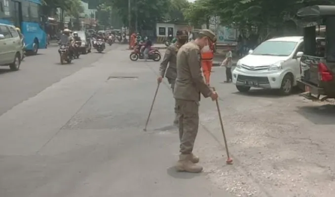 Petugas Satpol PP Jakarta Timur sedang melakukan penyisiran ranjau paku di Jalan Raya Pondok Gede, Kelurahan Pinang Ranti, Kecamatan Makasar, Jakarta Timur, Kamis (14/10/2021) (ist)