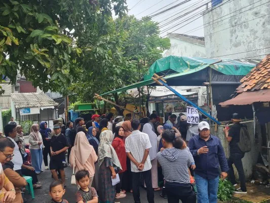 Warga Kampung Guji antre melakukan pencoblosan usai relokasi TPS karena terdampak banjir. (Pandi)