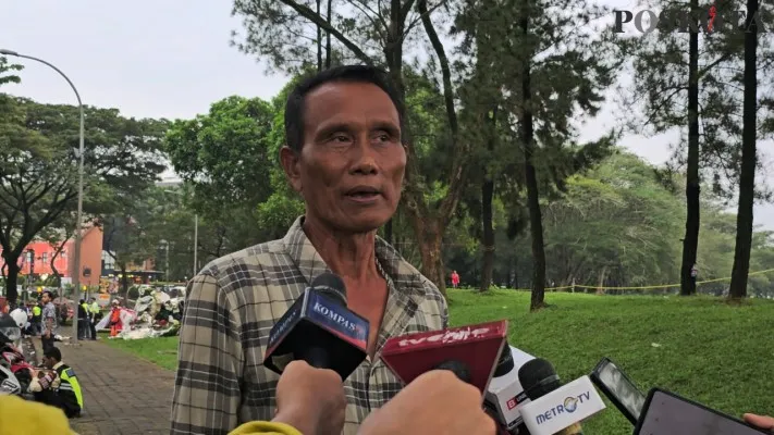 Seorang saksi mata bernama Ali (50) saat menceritakan salah seorang korban pesawat jatuh meminta tolong di Lapangan Sun Burst, BSD City, Serpong, Kota Tangerang Selatan (Tangsel) pada Minggu, 19 Mei 2024. (Poskota.co.id/Veronica Prasetio)