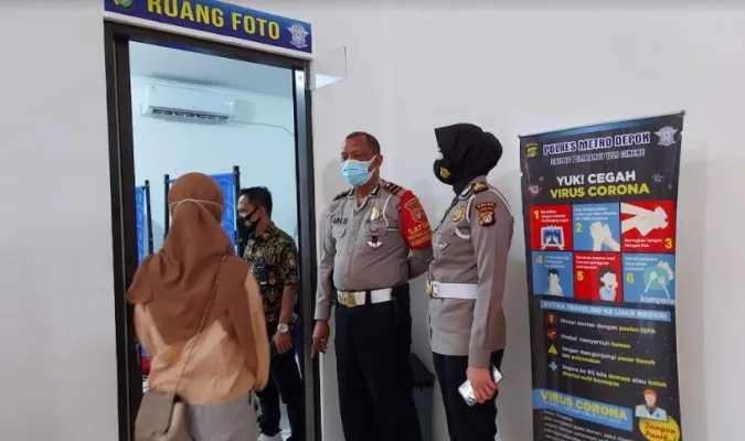 Kasubnit Satpas 1221 pembantu Sukmajaya Satlantas Polres Metro Depok, Ipda H. Ari didampingi Kanit Regident AKP Ernawati mengecek lokasi perpanjangan SIM langsung tertib (angga)