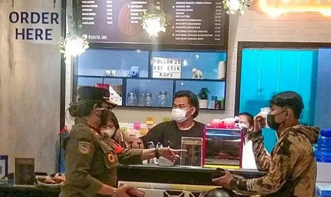 Petugas Satpol PP saat memberi sanksi pada tempat makan dan kafe di wilayah Koja, Jakarta Utara. (Foto/satpolppkoja)