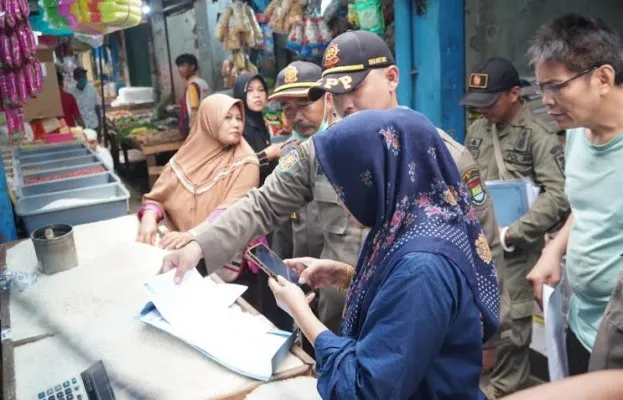 Satpol PP Kabupaten Tangerang saat mendistribusikan surat teguran kepada pedagang Pasar Kutabumi. (Foto/Veronica)