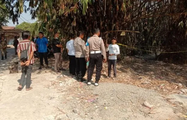 Petugas saat memasang garis polisi di lokasi pengeboran sumur. (Foto/Veronica)