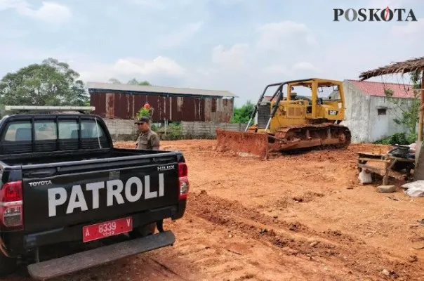 Petugas Satpol PP Kabupaten Tangerang saat memasang Pol PP Line pada buldoser. (Foto/Veronica)