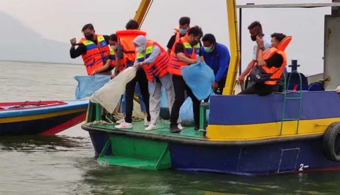 PJT dan kalangan media sedang menebar 5.000 benih ikan di Waduk Jatiluhur.(ist)